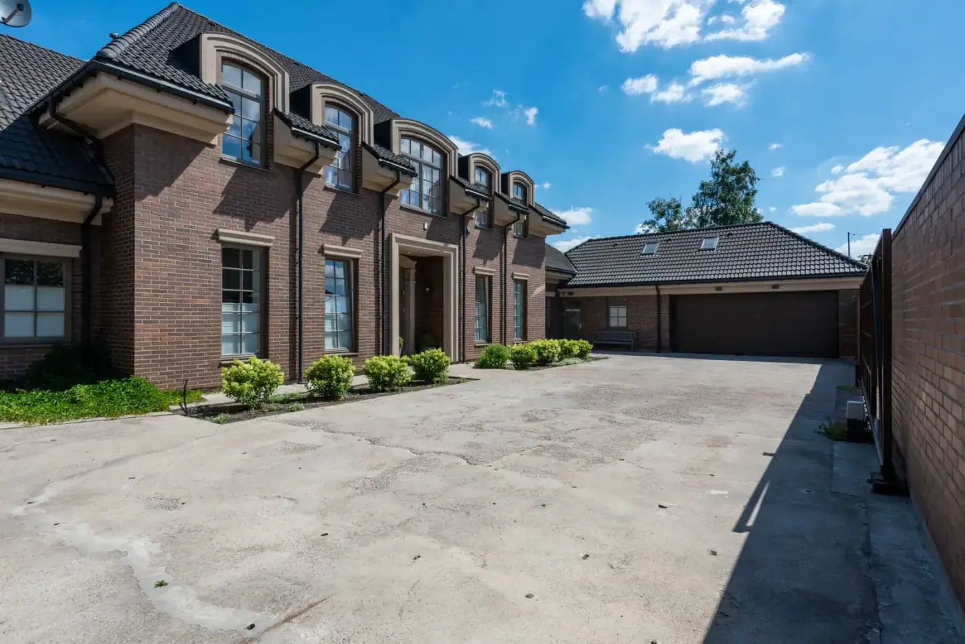 Large brick building with a broad concrete approach and parking apron