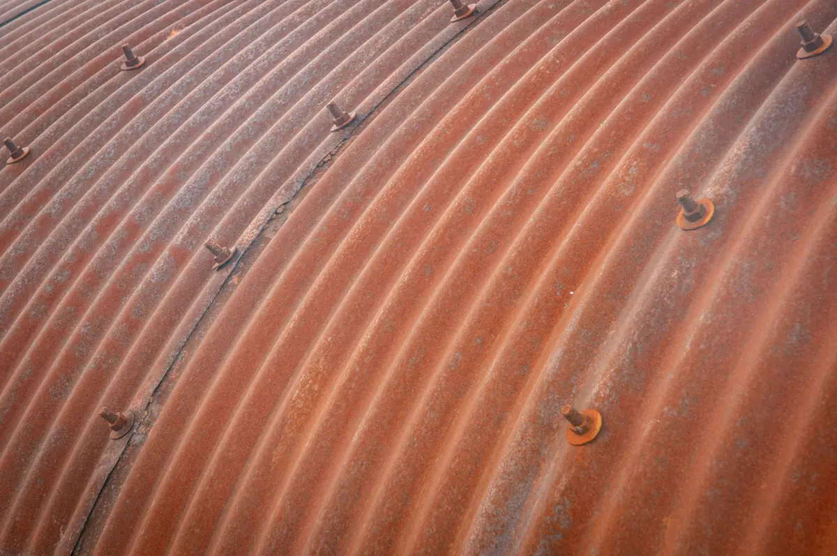 Rusted corrugated metal sheeting, orange weeping from every bolt